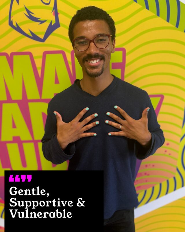 Aaron Morris holding up his painted nails. His three words: Gentle, Supportive and Vulnerable.
