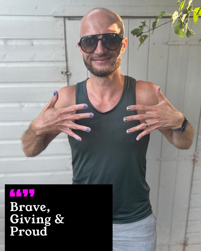 Chris Holmes holding up his painted nails. His three words: Brave, Giving and Proud.