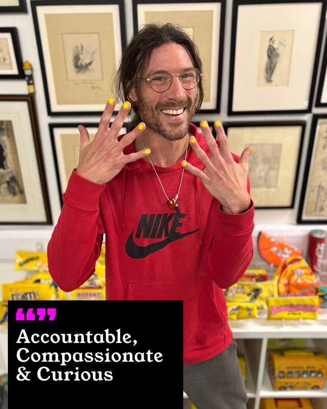 Chris Horn holding up his painted nails. His three words: Accountable, Compassionate and Curious.