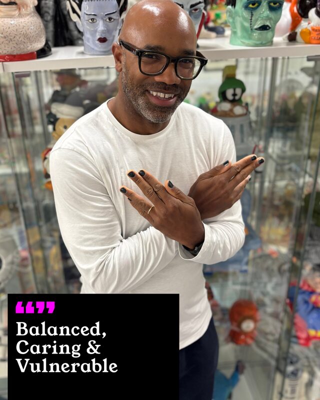 Curtis Weir holding up his painted nails. His three words: Balanced, Caring and Vulnerable.