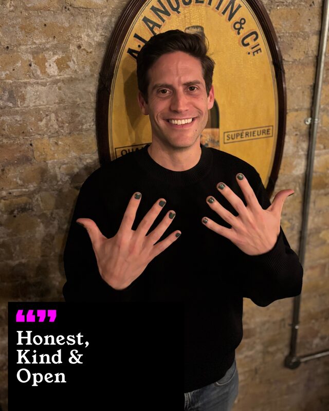 Elliot Milne holding up his painted nails. His three words: Honest, Kind and Open.
