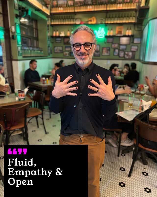 Fabio Simões holding up his painted nails. His three words: Fluid, Empathy and Open.