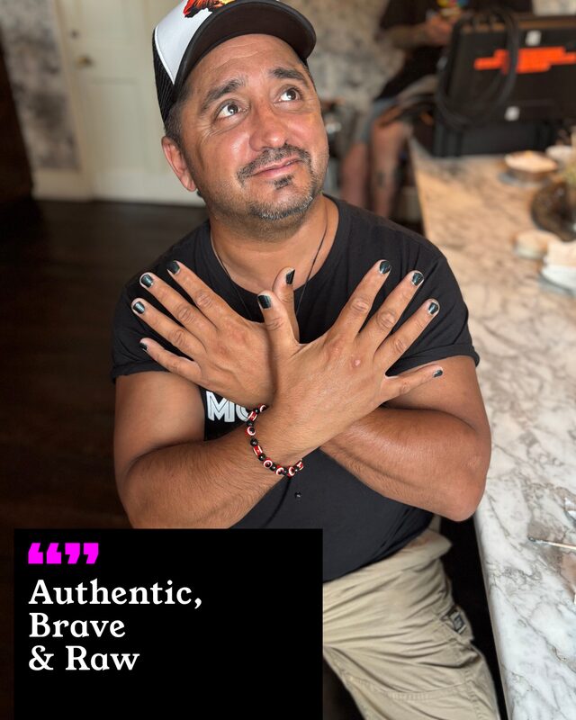 Jazz Singh holding up his painted nails. His three words: Authentic, Brave and Raw.