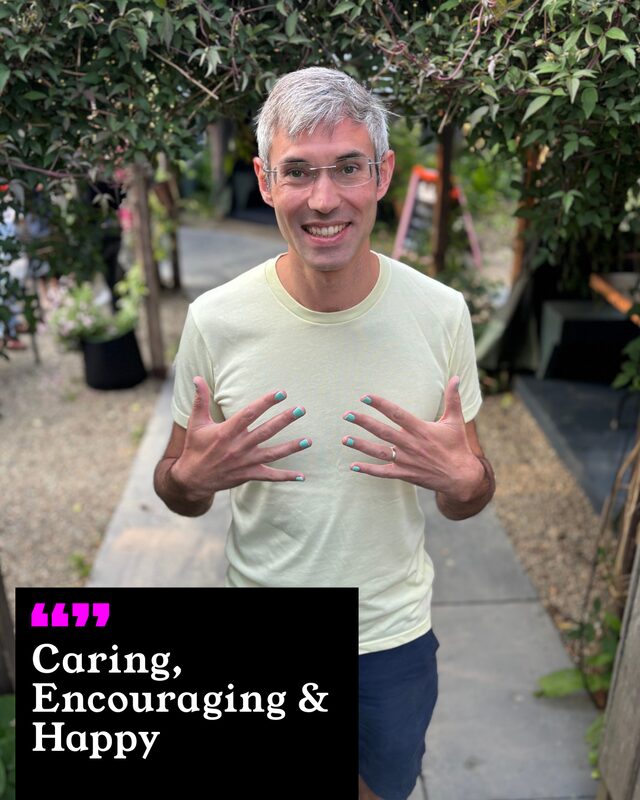 Jeremy Yeates holding up his painted nails. His three words: Caring, Encouraging and Happy.
