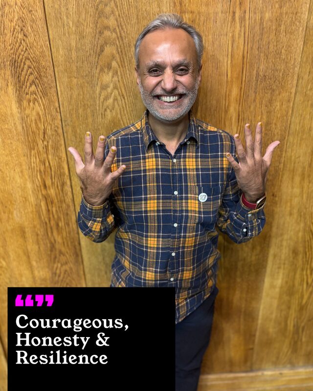 Jit Thaker holding up his painted nails. His three words: Courageous, Honesty and Resilience.