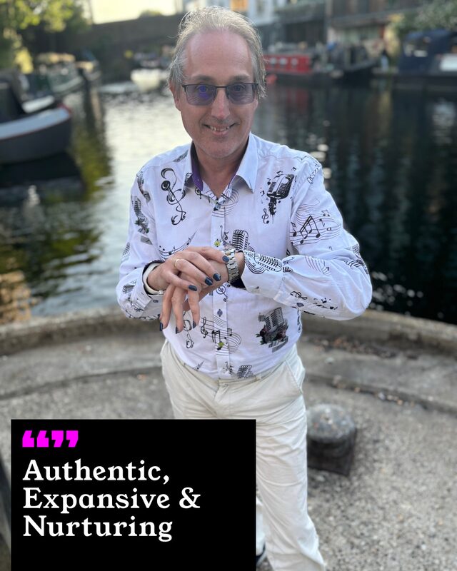 John Carmen holding up his painted nails. His three words: Authentic, Expansive and Nurturing.