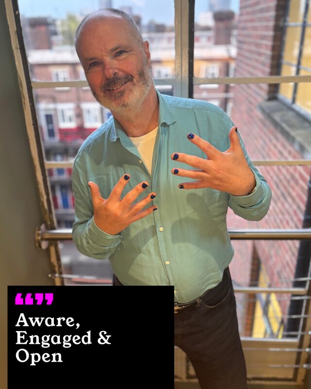 Kevin O’Neil holding up his painted nails. His three words: Aware, Engaged and Open.
