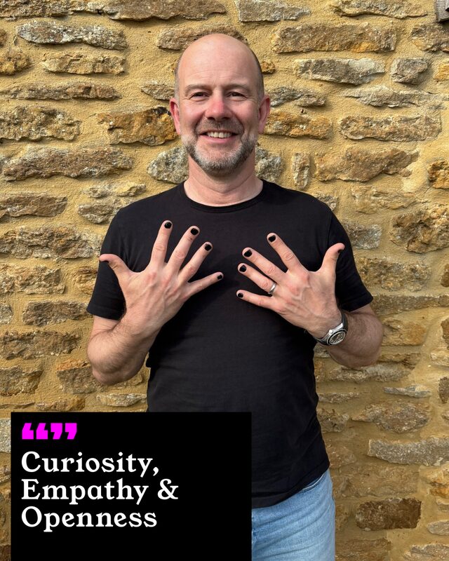 Marc Tobias holding up his painted nails. His three words: Curiosity, Empathy and Openness.