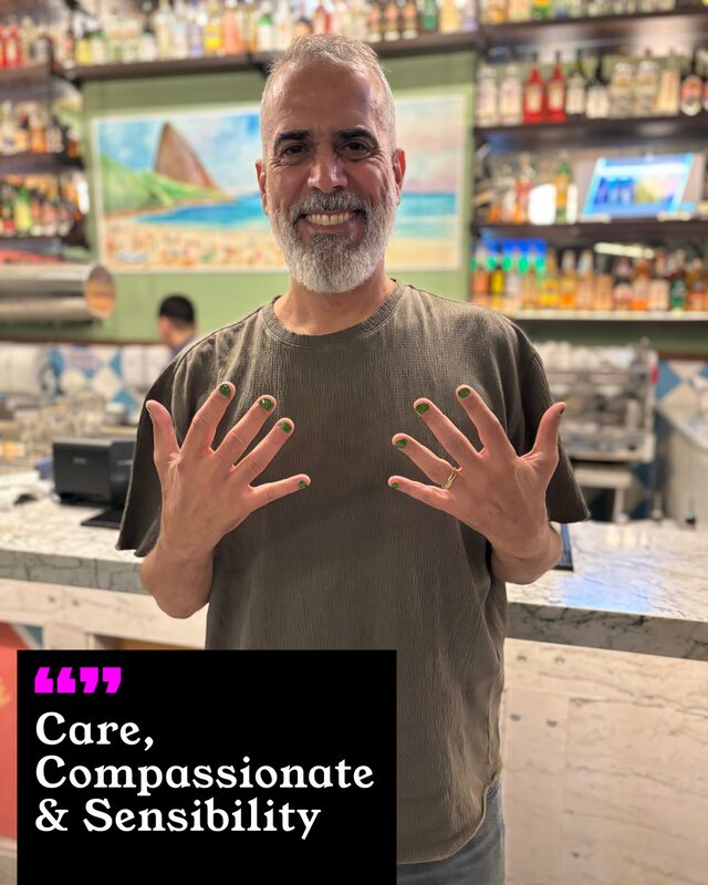 Mauro Caveletti holding up his painted nails. His three words: Care, Compassionate and Sensibility.