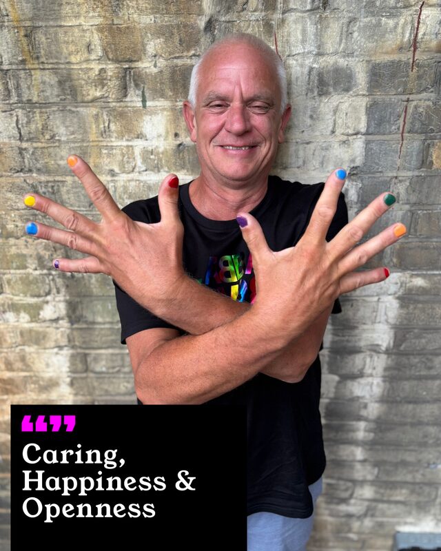 Micheal Warnes holding up his painted nails. His three words: Caring, Happiness and Openness.