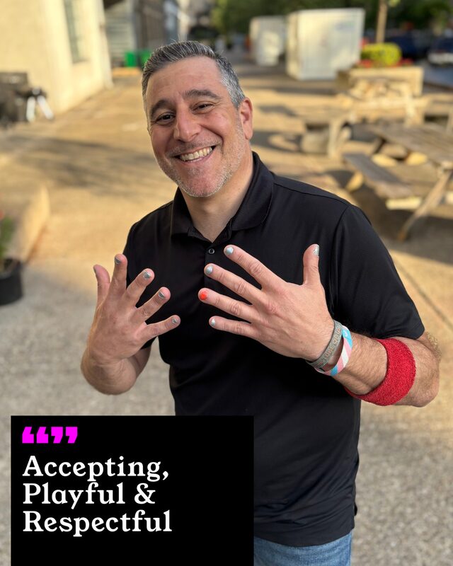 Paul Sanbar holding up his painted nails. His three words: Accepting, Playful and Respectful.