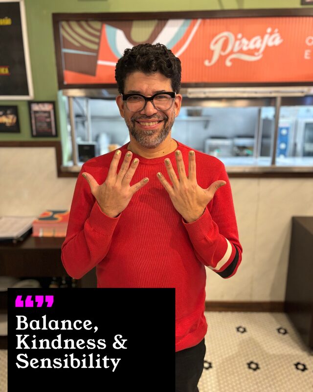 Ricardo Figueria holding up his painted nails. His three words: Balance, Kindness and Sensibility.