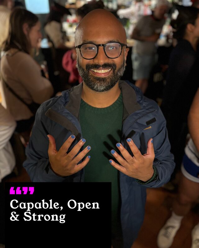 Sanj Ambalavanar holding up his painted nails. His three words: Capable, Open and Strong.