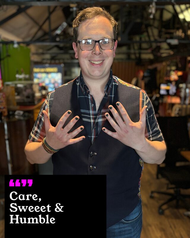 A participant holding up his painted nails. His three words: Care, Sweet and Humble.