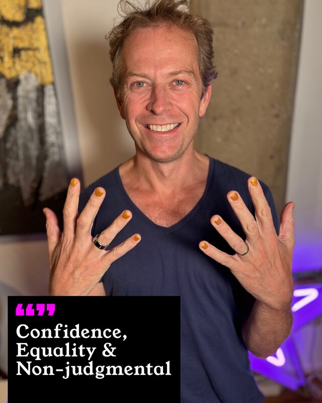 Wayne Arnold holding up his painted nails. His three words: Confidence, Equality and Non-judgmental.