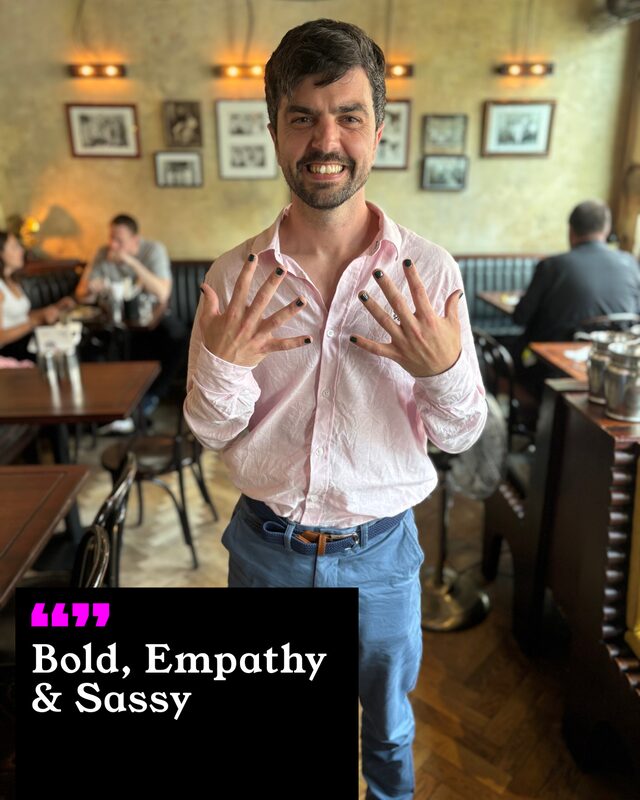 Will Adoolphy holding up his painted nails. His three words: Bold, Empathy and Sassy.