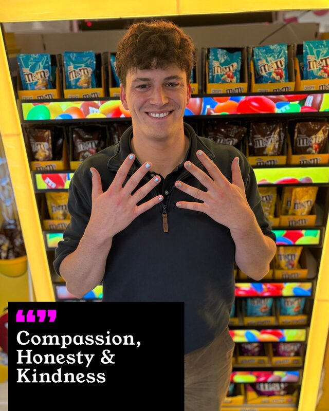 Zack Hersov holding up his painted nails. His three words: Compassion, Honesty and Kindness.