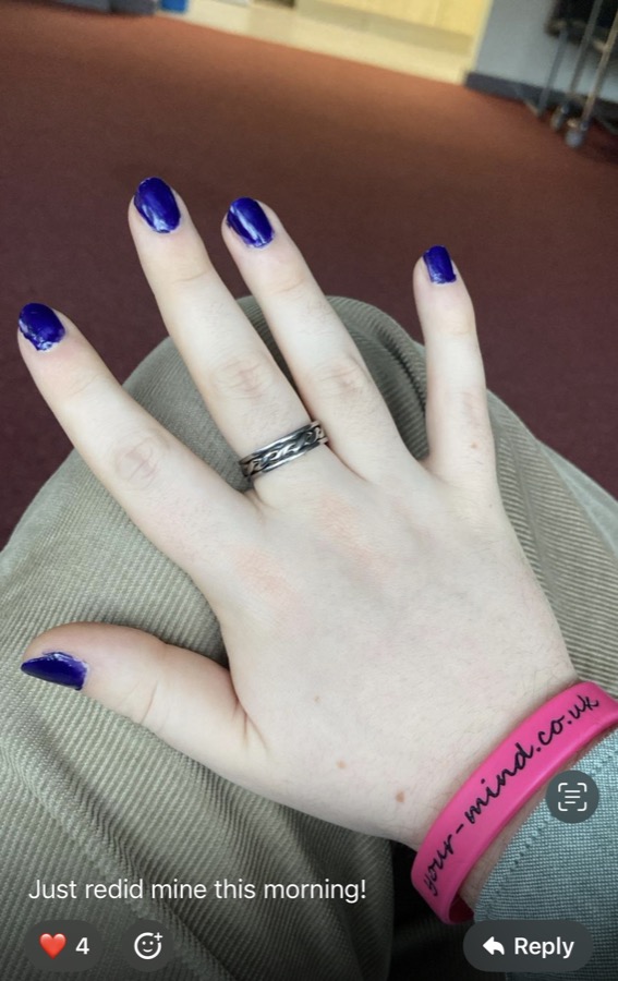 A hand with deep purple nails and a charity wristband. The participant wrote: Just redid mine this morning